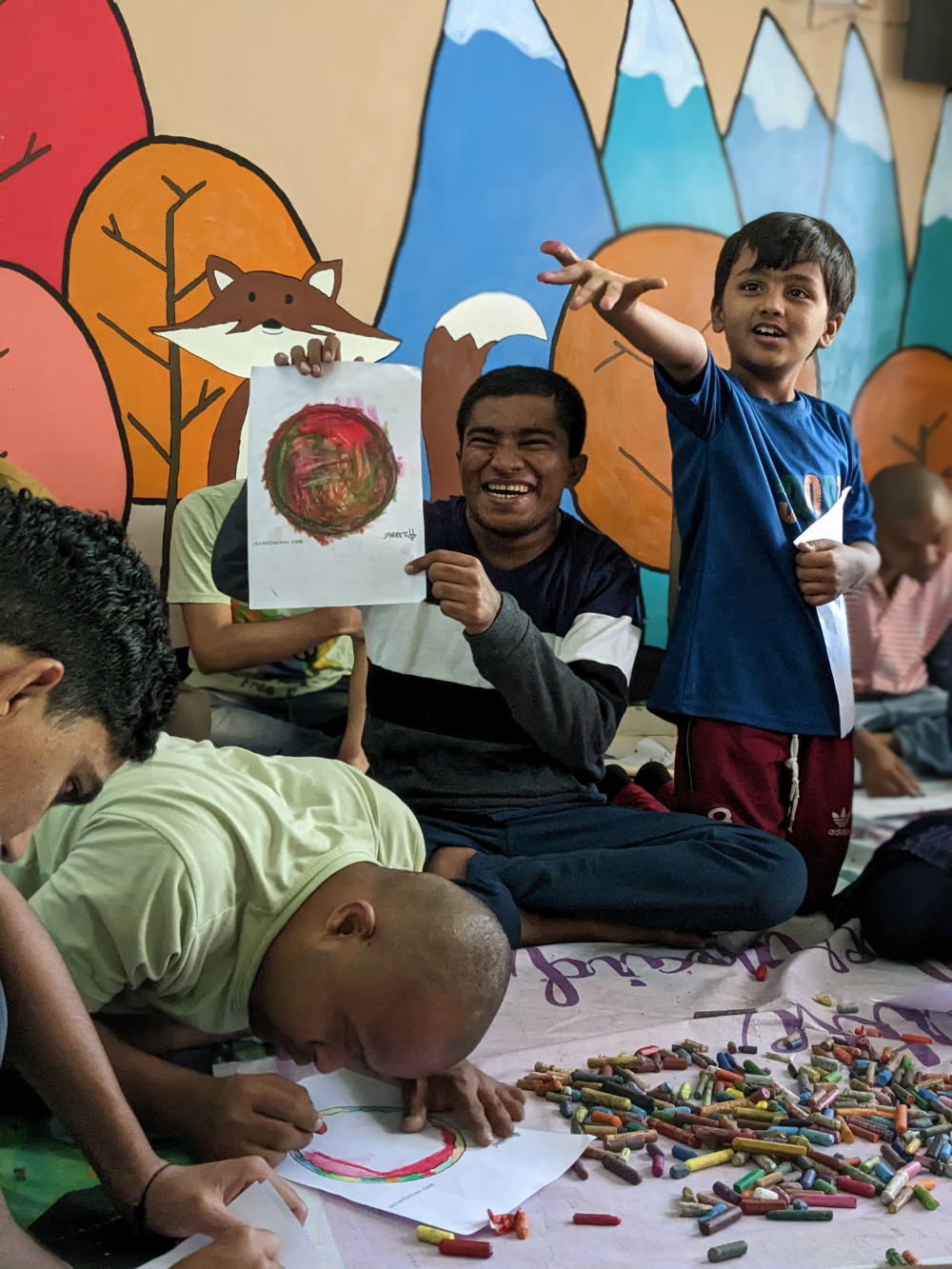 Arts-Based Therapy — a beneficiary holding up a painting