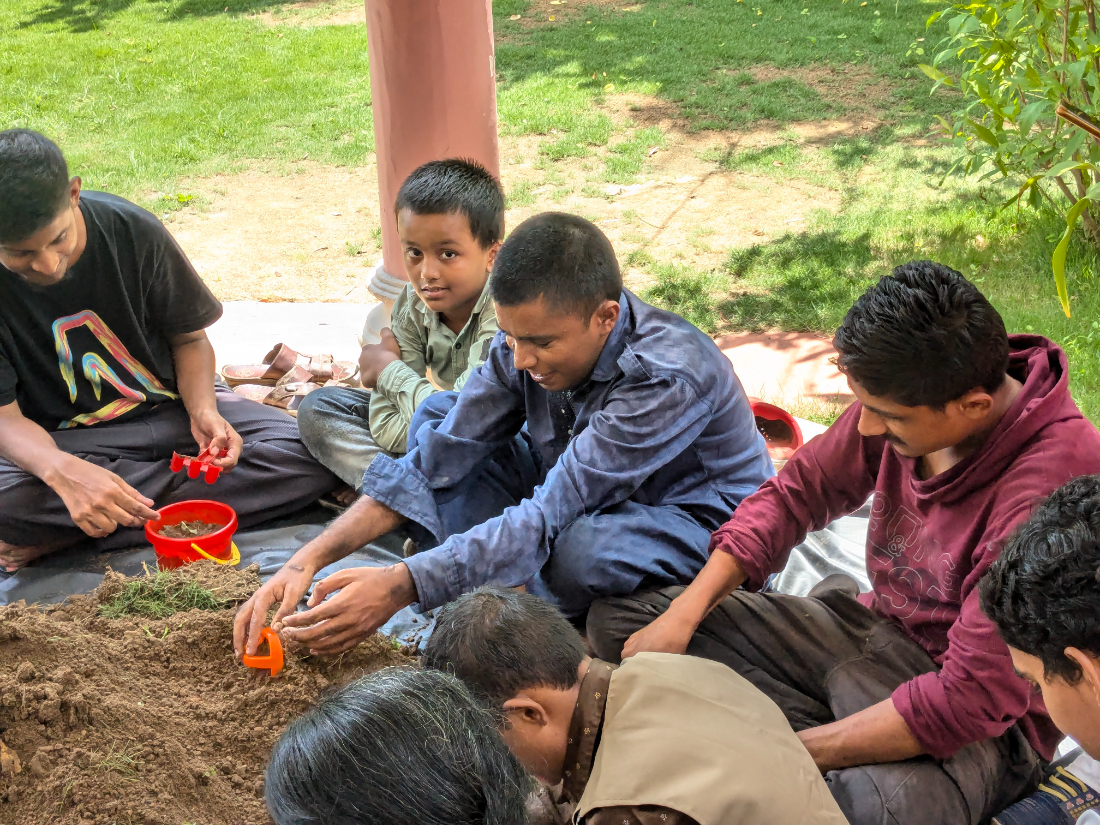 Children planting seedlings in soil together during an ESI session